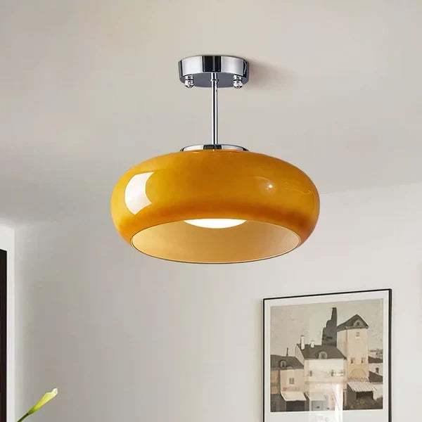 Szklana lampa sufitowa w chromie i pomarańczu nad pokojem dziennym