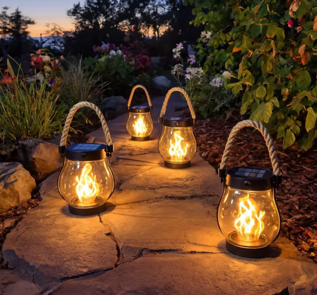 Kilka lampionów solarnych z przezroczystym szkłem wzdłuż ścieżki ogrodowej