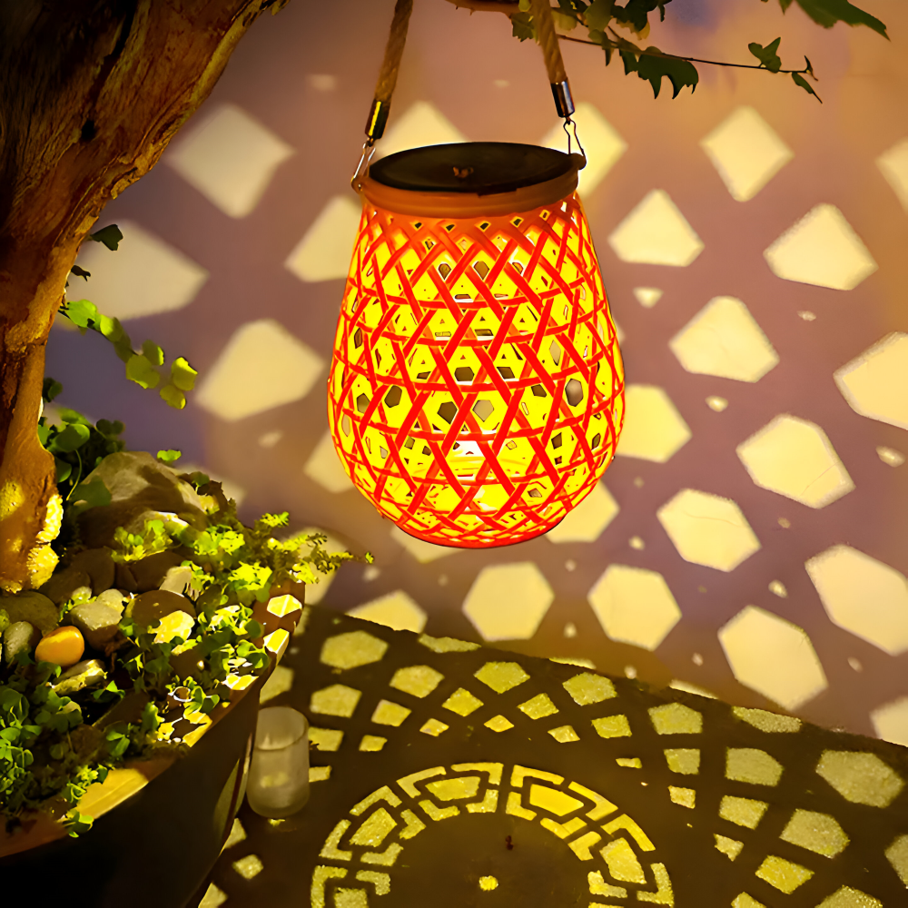 Lampion solarny na drzewie rzucający wzory światła