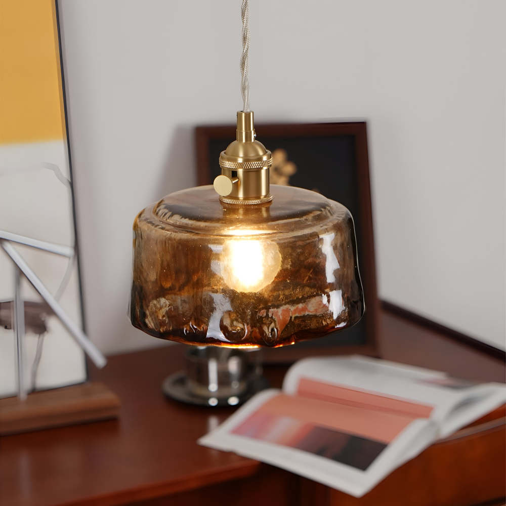 Lampa wisząca ze szklanym kloszem nad biurkiem z otwartym magazynem