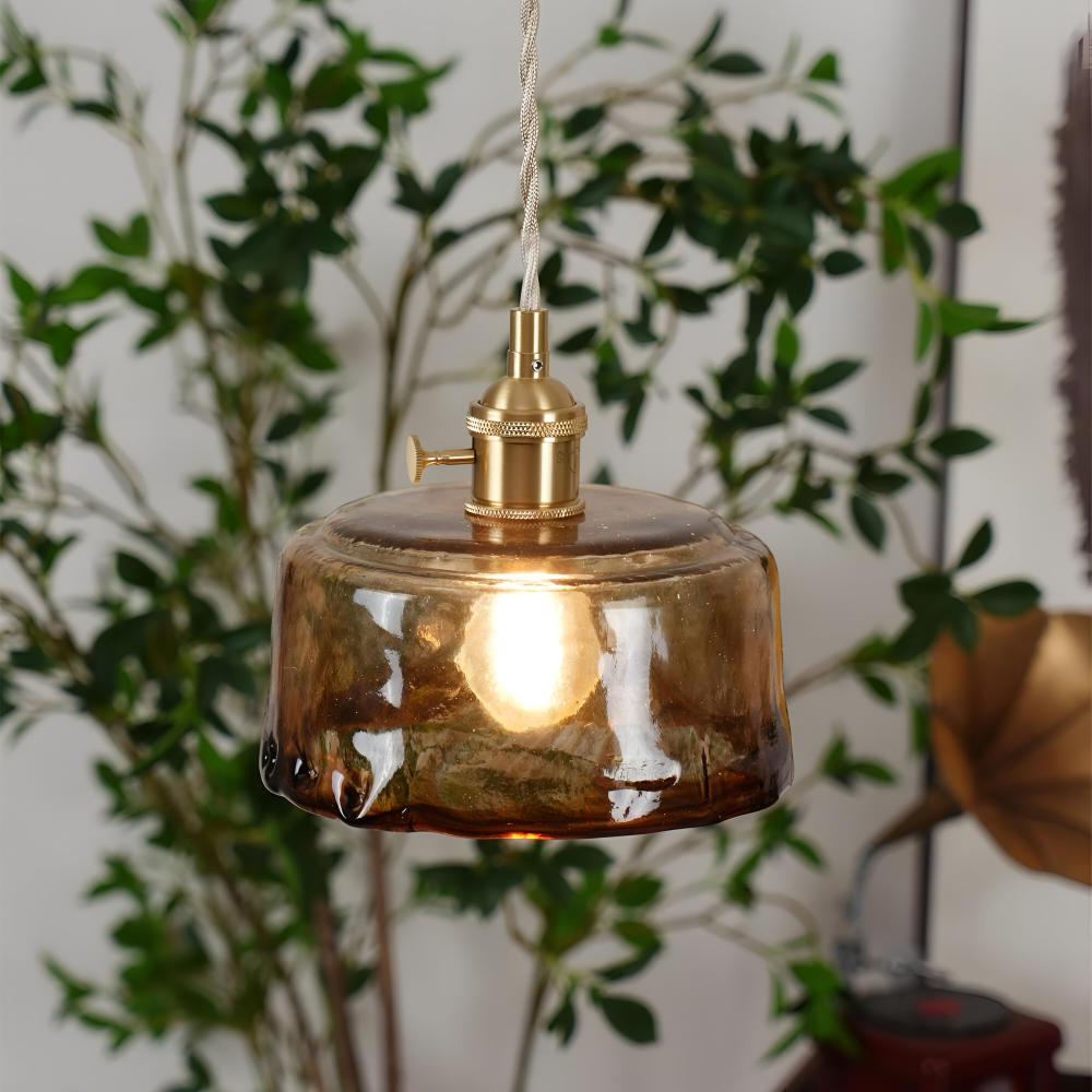 Szklany klosz lampy wiszącej wśród zielonych liści, zbliżenie