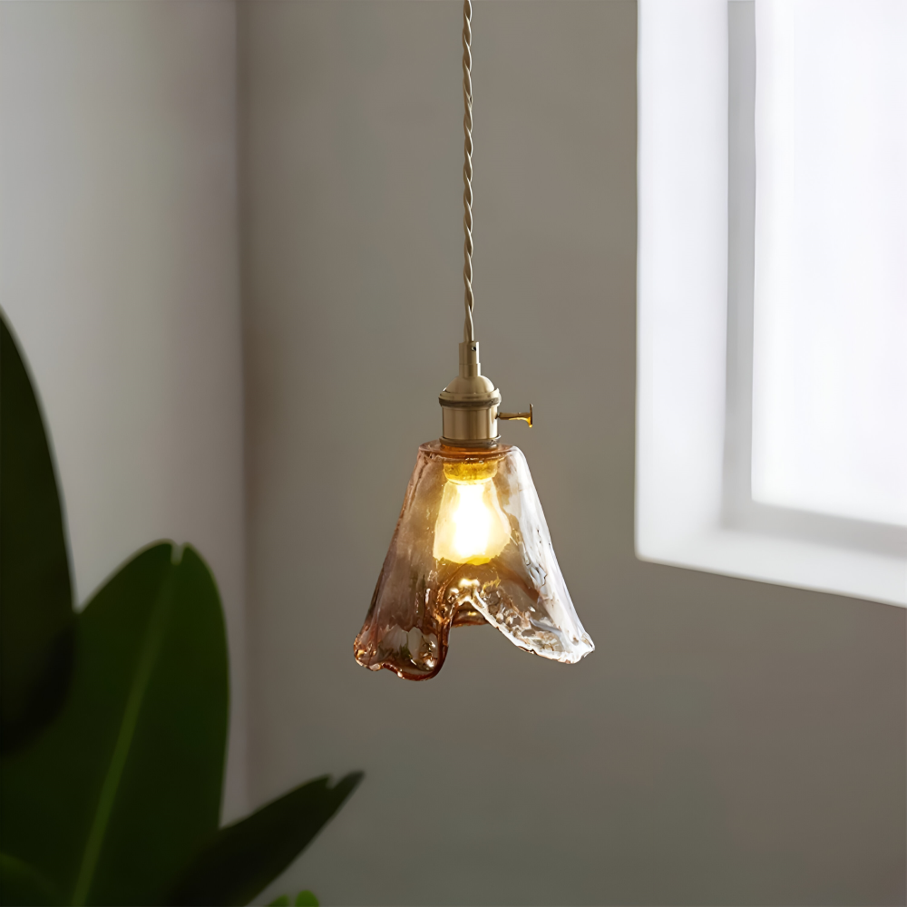 Falowany brzeg szklanego klosza lampy wiszącej przy oknie