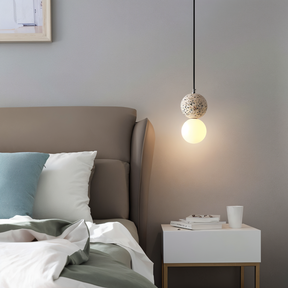 Lampa wisząca z jasnego lastryko nad białą szafką nocną przy łóżku