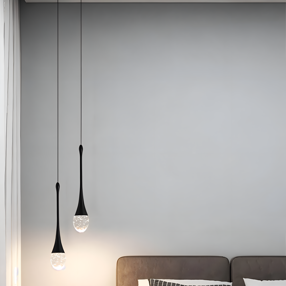 Dwie czarne lampy wiszące kropla przy jasnej ścianie nad siedziskiem