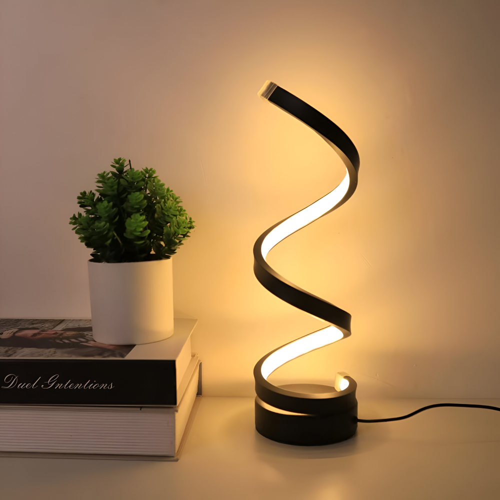 Lampka nocna spirala obok książek i rośliny