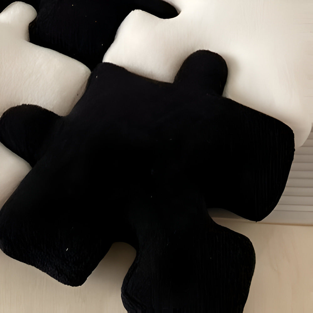Czarna pluszowa poduszka dekoracyjna w kształcie puzzla, zbliżenie