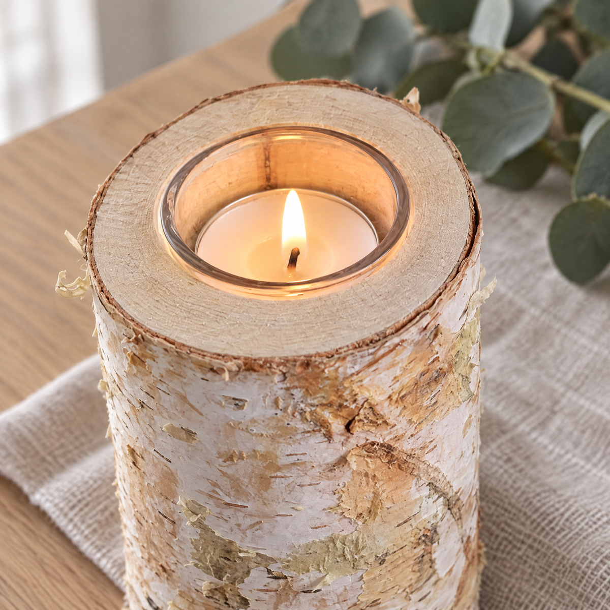Zbliżenie świecznika na tealight z drewna brzozowego z naturalną korą i szklanym wkładem