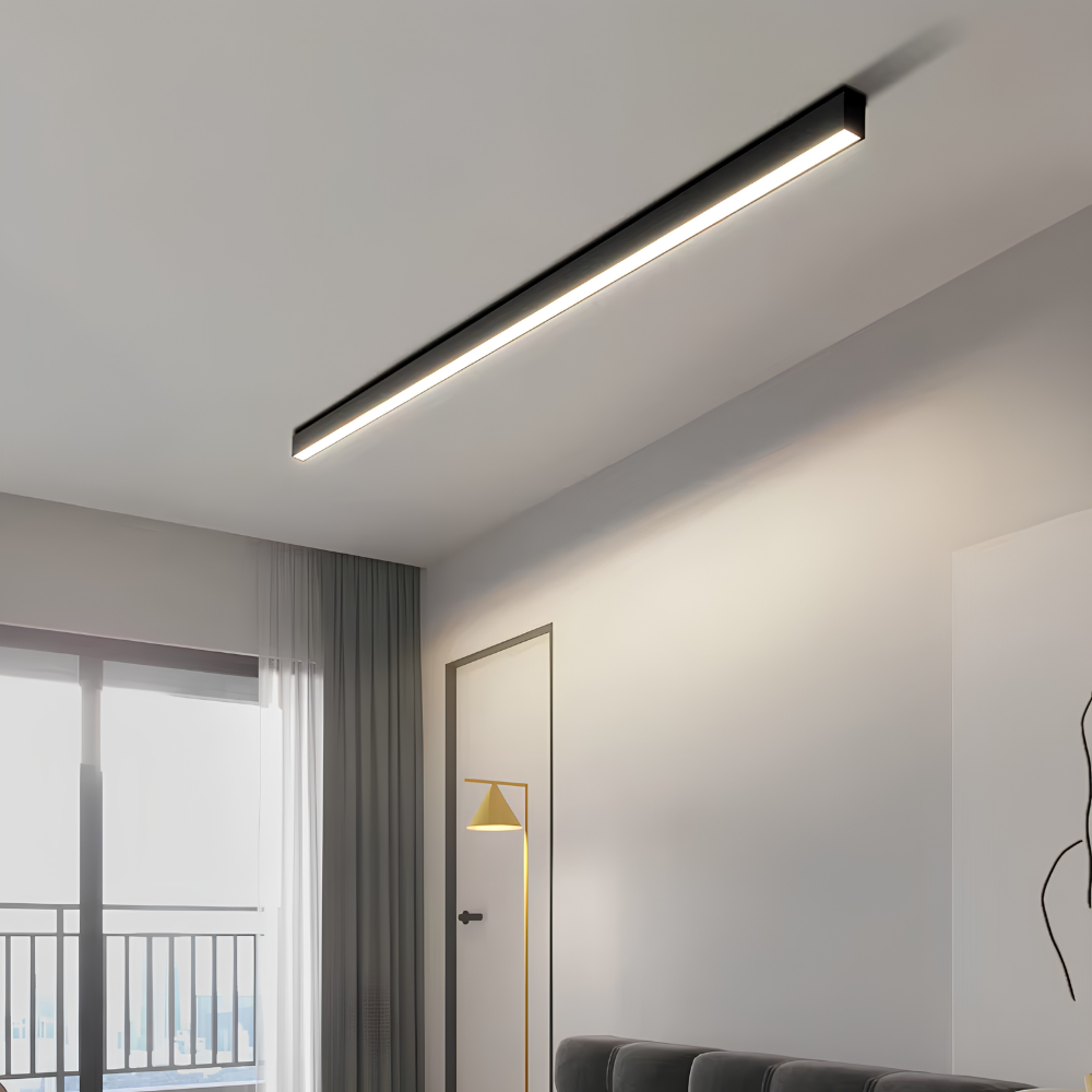 Czarna liniowa lampa sufitowa LED świecąca nad strefą wypoczynkową w salonie