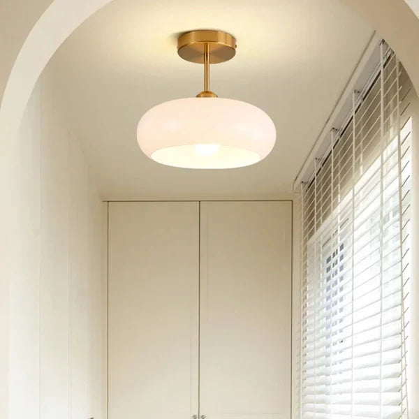 Szklana lampa sufitowa we wnęce w przedpokoju z ciepłym światłem