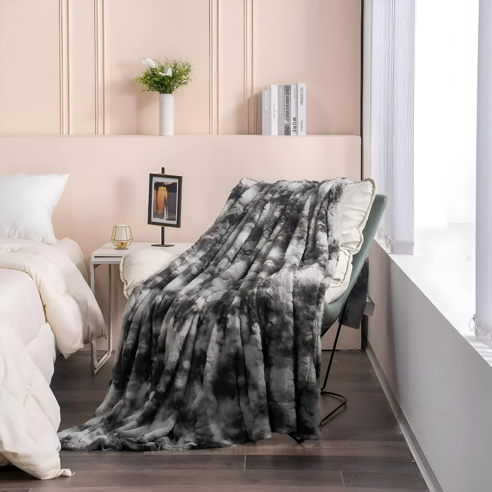 Puszysty koc 160x200 cm tie-dye w odcieniach szarości przewieszony przez fotel w sypialni