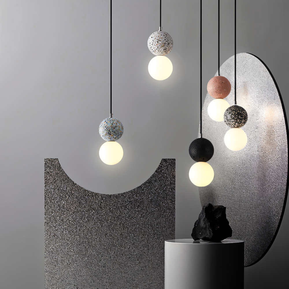Lampy wiszące z kulami z lastryko przy szarej ścianie z okrągłym lustrem